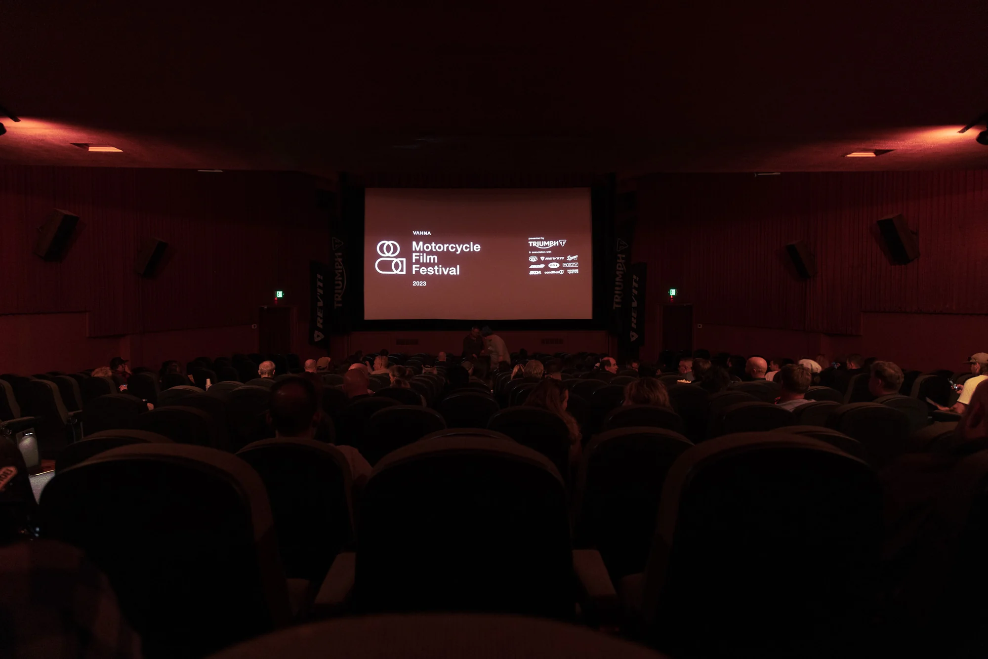 Festival audience seated inside the dark red Cinema 21 auditorium before the program.